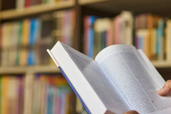 Olgun bir adam kütüphanesinden bir kitabı dikkatlice inceliyor, fotokopi alanı ile yakın çekim.