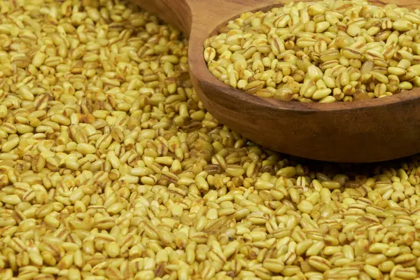 Kırsal bir arka planda tam buğday. Seramik ve ahşap kaplarla buğday taneleri, yakın plan fotoğraf..