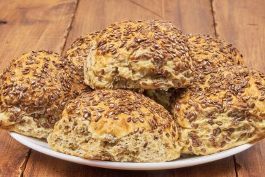 Tam tahıl konsepti. Keten tohumlarıyla süslenmiş ev yapımı tam buğday ekmeği, yakın plan fotoğraf.