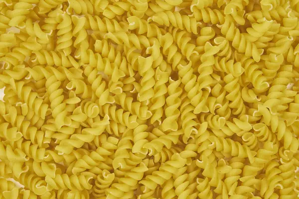 Desenli arkaplanı ve kopyalama alanı olan ham fusilli makarna tam resmi