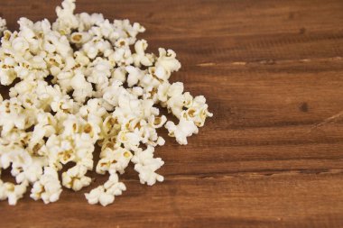 Ön plandaki tahta masada patlamış mısır ve fotokopi alanı.