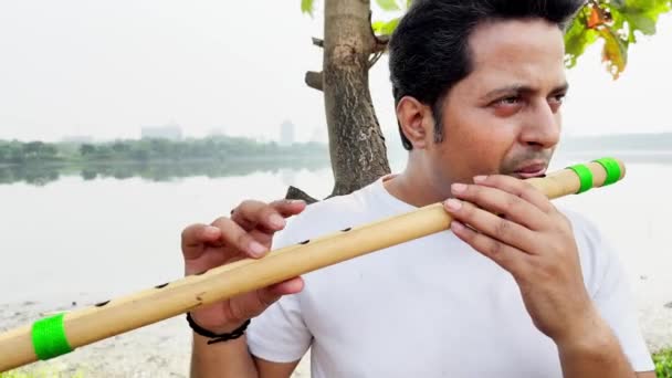 Man Playing Traditional Flute Outdoors River Background — Stock Video
