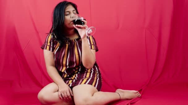 Femme Élégante Assise Tenant Verre Vin Rouge Sur Fond Rouge — Video