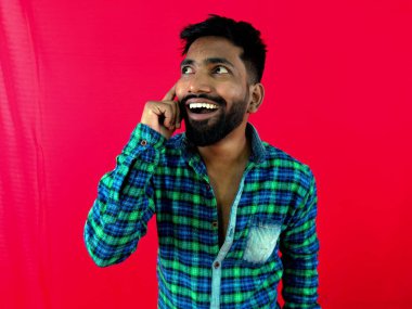 Genç adam bir fikir buldu. Kırmızı arka planda çok heyecanlı ve mutlu..