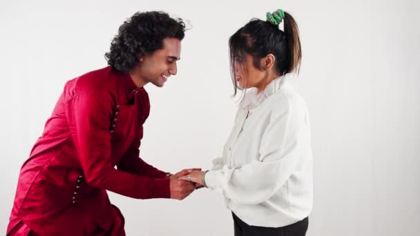 女性の手を握り 白い背景との結婚のために彼女を提案する伝統的な服装の笑顔の男 — ストック動画