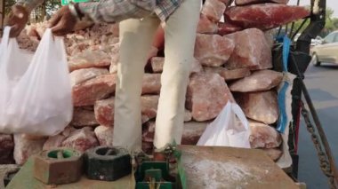 Kırsal kesimde tuz satan bir yerde, tepe örtüsünün altında pembe tuz kayaları olan kırsal yol kenarı kamyonu.