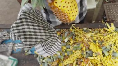 Sokak satıcıları renkli bir meyve tezgahında ananas soyarken ve keserken usta bir şekilde sokakta meyve satarken... 
