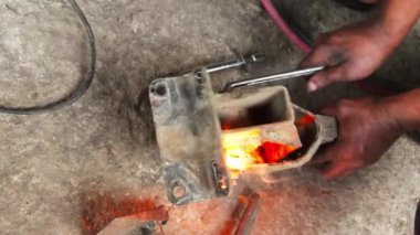 Metal atölyedeki tezgahta dururken kaynak makinesinin elinde kıvılcımlar uçuşuyor.