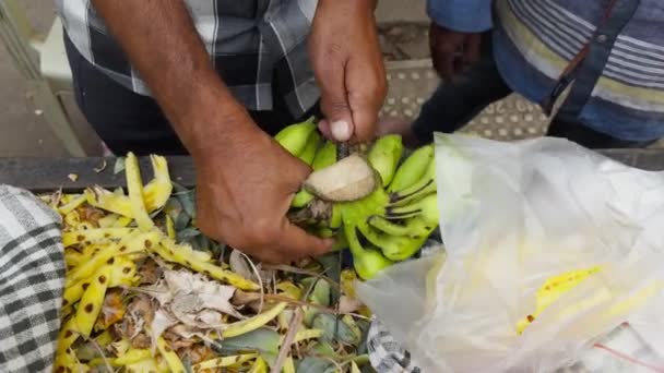 Person Cutting Green Bananas Plastic Bag Market Stall Banana Peels — Vídeo de Stock