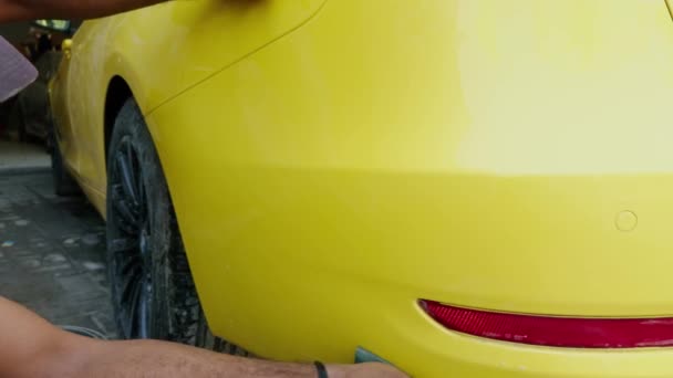 Człowiek Myje Ręce Żółty Samochód Sportowy Przed Malowaniem Gąbką Wiadrem — Wideo stockowe