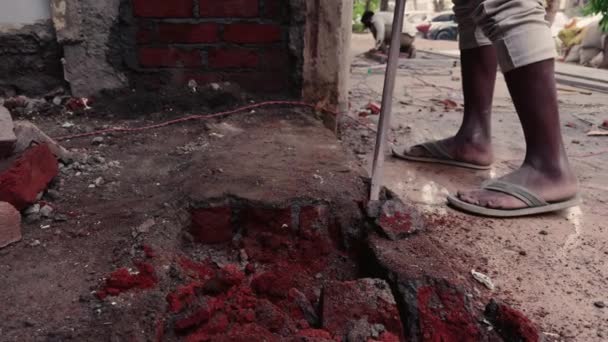 房屋重建中用金属棒在工地上工作的人 砸碎砖和瓦砾 — 图库视频影像