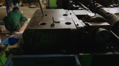 Esnaf, torna makinesini torna atölyesinde, torna atölyesinde araç parçaları yapmak için cıvata iplikleri üreten aletlerle kullanıyor.