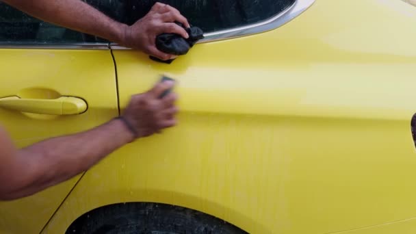 Człowiek Myje Ręce Żółty Samochód Sportowy Przed Malowaniem Gąbką Wiadrem — Wideo stockowe