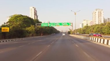 Açık bir şehir binalarında hafif trafik olan şehir yolu ve otoyolda veya otobanda giden mavi gökyüzü, Asya, Hindistan