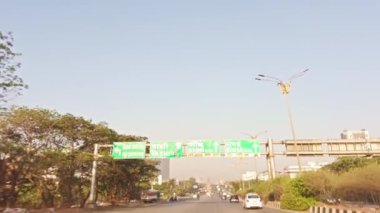 Açık bir şehir binalarında hafif trafik olan şehir yolu ve otoyolda veya otobanda giden mavi gökyüzü, Asya, Hindistan 