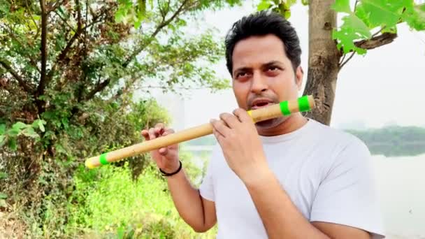 Человек Играет Традиционной Флейте Открытом Воздухе Природой Озером Заднем Плане — стоковое видео