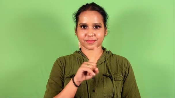 微笑自信的女人 用手指在绿色屏幕的背景上表示不同意 — 图库视频影像