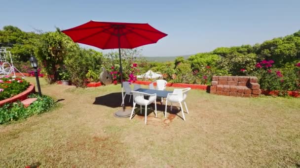 Outdoor Garden Cafe Red Umbrella White Chairs Lush Greenery Clear — Stock Video
