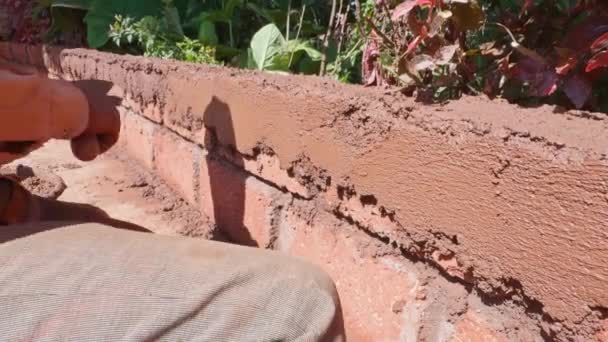工人用铁钳在建筑用的墙壁上用新鲜的水泥粘贴 用工具集中在手上 — 图库视频影像