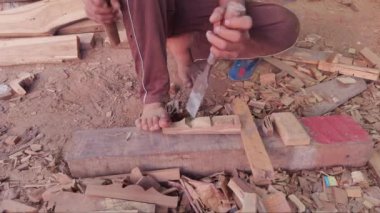 Asya ve Hindistan 'daki bir şantiyede bir marangozun elleri keski ve çekiçle tahta üzerine yakın plan.