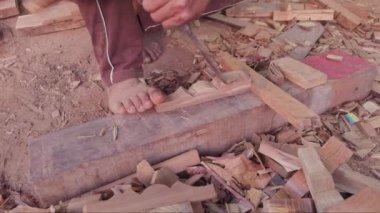Asya ve Hindistan 'daki bir şantiyede bir marangozun elleri keski ve çekiçle tahta üzerine yakın plan.