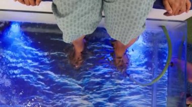 Balık spa 'sında, Asya' da, Hindistan 'da küçük balıkların ayaklarını kemirdiği balık pedikür terapisi gören bir kadın.