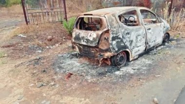Yol kenarında yanmış ve terk edilmiş bir araba enkazı var. Yol kenarında, Asya 'da, Hindistan' da park halindeki bir otoyolda kaza üstüne yangın ve yangın sonucu oluşan hasar görülüyor.