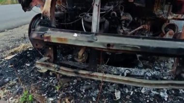 Yol kenarında yanmış ve terk edilmiş bir araba enkazı var. Yol kenarında, Asya 'da, Hindistan' da park halindeki bir otoyolda kaza üstüne yangın ve yangın sonucu oluşan hasar görülüyor.