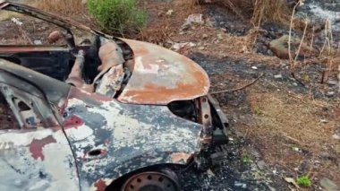 Yol kenarında yanmış ve terk edilmiş bir araba enkazı var. Yol kenarında, Asya 'da, Hindistan' da park halindeki bir otoyolda kaza üstüne yangın ve yangın sonucu oluşan hasar görülüyor.