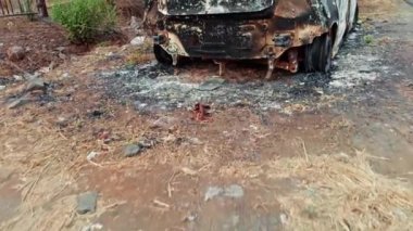 Yol kenarında yanmış ve terk edilmiş bir araba enkazı var. Yol kenarında, Asya 'da, Hindistan' da park halindeki bir otoyolda kaza üstüne yangın ve yangın sonucu oluşan hasar görülüyor.