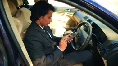 Sürücü koltuğunda oturan genç bir avukat, iş adamı arabayla gezici ekrana çıkıyor, Hintli bir adam sosyal medya uygulamaları yüklüyor.