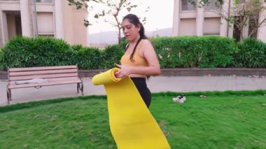 Parkta yoga minderi örten bir kadın, atletik giyinen bir kadın, paspas örten bir kadın, bahçede dikilen güzel bir kadın, Hintli bir kadın.