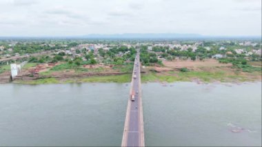 Köprüdeki kırsal ekspres yol, derenin üzerinden geçen yol manzarası, bir kasabanın iki bölgesini birbirine bağlayan köy evleri, yeşillikler, binalar, onu süren araçlar, Hindistan, Suyolu