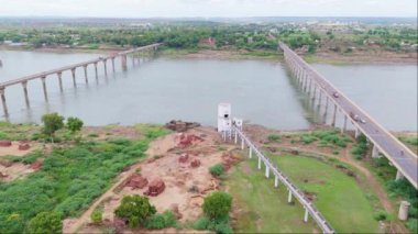 Birden fazla köprüsü olan bir nehrin havadan görünüşü, oradan geçen kamyonlar, yeşillik ve küçük bir kasaba, çekimin üstündeki Ganga kanalı, Hindistan