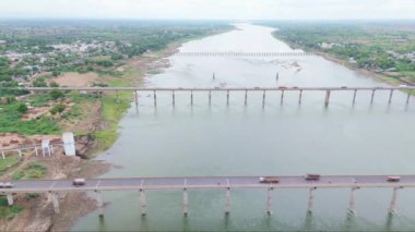Birden fazla köprüsü olan bir nehrin havadan görünüşü, oradan geçen kamyonlar, yeşillik ve küçük bir kasaba, çekimin üstündeki Ganga kanalı, Hindistan