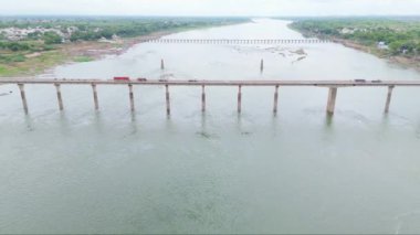 Birden fazla köprüsü olan bir nehrin havadan görünüşü, oradan geçen kamyonlar, yeşillik ve küçük bir kasaba, çekimin üstündeki Ganga kanalı, Hindistan