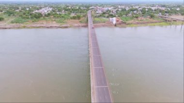 Köprüdeki kırsal ekspres yol, derenin üzerinden geçen yol manzarası, bir kasabanın iki bölgesini birbirine bağlayan köy evleri, yeşillikler, binalar, onu süren araçlar, Hindistan, Suyolu