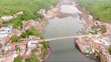Küçük bir kasabadaki nehir köprüsünün hava manzarası, göl tatil noktalı güzel bir köy, tekneler ve iki tarafı birbirine bağlayan süspansiyon üstgeçidi, Townlet, Turizm yeri, Hindistan