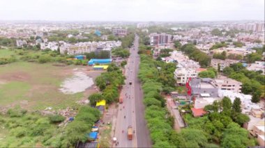 Ana yolu ve yeşil alanları olan şehrin hava manzarası, Jaipur şehir giriş otoyolu araçları, konut binaları, ağaçlar, Hindistan turistik alanlarıyla çevrili.