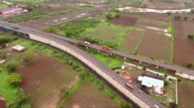 Otoyol araçlarının üstgeçitte, tren raylarında, arabalarda ve kamyonlarda, kesişen tren yollarında, Hindistan 'da hava görüntüsü. 