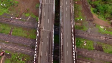 Otoyol araçlarının üstgeçitte, tren raylarında, arabalarda ve kamyonlarda, kesişen tren yollarında, Hindistan 'da hava görüntüsü. 