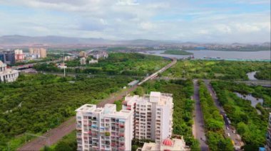 Bombay şehrinin havadan manzarası, Palm Beach yolu yüksek binalar ve yeşillik, ağaçlar ve su kütleleriyle çevrili büyük bir otoyol, bulanık, Yeni Bombay Hindistan