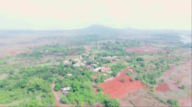 Bereketli bir kırsal alanın havadan görünüşü, yemyeşil, dağınık evler, toprak yollar, tarlalar, huzurlu doğal ortam, Hindistan