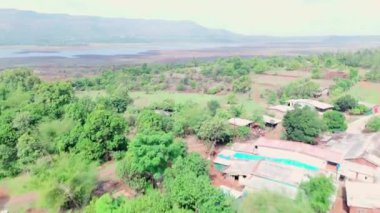 Doğa tarafından çevrelenmiş modern bir Villa 'nın havadan görünüşü, kırsal alanda güzel bir bungalov, Kızıl Topraklı tarım arazisi, yeşil ağaçlar, ekilmiş tarlalar, köy alanı, Hindistan kırsal kesimini gösteriyor.
