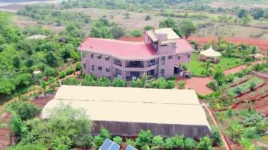 Doğa tarafından çevrelenmiş modern bir Villa 'nın havadan görünüşü, kırsal alanda güzel bir bungalov, Kızıl Topraklı tarım arazisi, yeşil ağaçlar, ekilmiş tarlalar, köy alanı, Hindistan kırsal kesimini gösteriyor.
