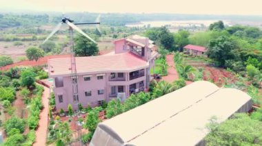 Doğa tarafından çevrelenmiş modern bir Villa 'nın havadan görünüşü, kırsal alanda güzel bir bungalov, Kızıl Topraklı tarım arazisi, yeşil ağaçlar, ekilmiş tarlalar, köy alanı, Hindistan kırsal kesimini gösteriyor.