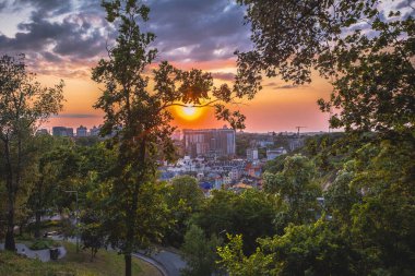 Şehir üzerinde Manzaralı Günbatımı Çerçeveli Lush Green Trees