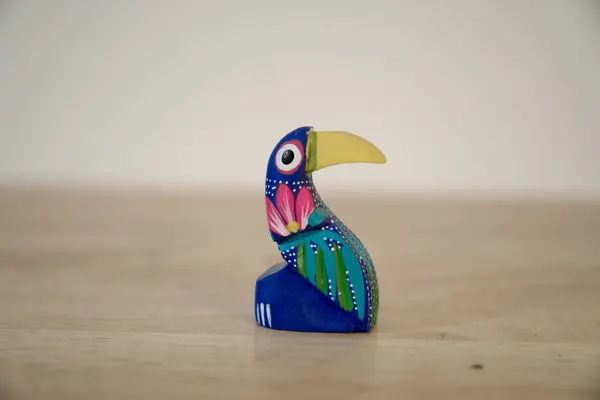 Alebrije beyaz arka planda tahtadan yapılmış renkli oyuncak kuş.