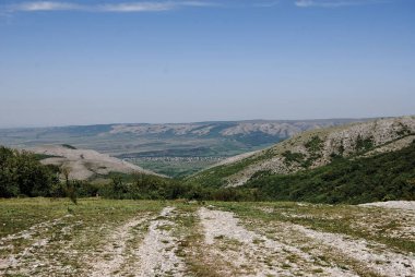 İki tepe arasında bir yerleşim yeri görülebilir. Kırım yarımadasının dağlık alanı, ovada nüfuslu bir bölge görülebilir..