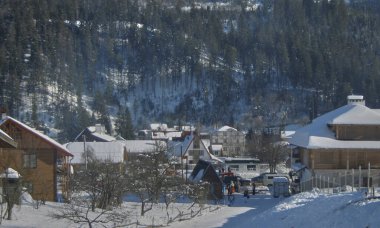 Karpat dağlarında kış tatili. Dağlık yamaçlar karla kaplı, bir sürü turist, turist kulübeleri, yazlık evler ve tabii ki kayak yamaçları..